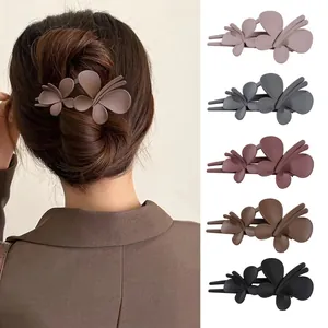 Detailed view of matte butterfly hair clips in five Morandi colors on a model and flat lay