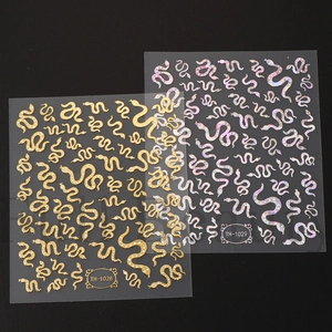 Detail of gold and holographic snake nail stickers TH-1028 and TH-1029 with starbursts