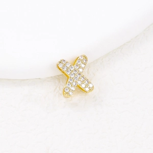 Macro shot of gold-plated X letter pendant with pavé set sparkling zircon stones