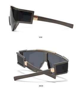 Detail view of coffee-colored oversized sunglasses with golden accents and wide temples