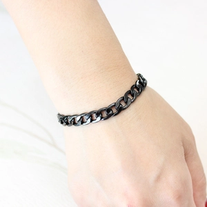 Polished black stainless steel Cuban link chain bracelet shown on a model wrist