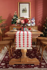 Close-up of red and white striped table runner with tassel fringe and diamond patterns