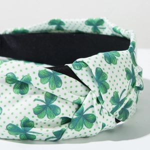 Detail view of the green clover pattern and fabric texture on a knotted headband