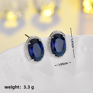 Macro shot of halo stud earring with dark blue oval stone, sized 1.47cm by 1.05cm
