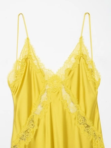 Détail d'un caraco en satin de soie jaune avec dentelle délicate et fines bretelles