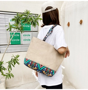 Ethnic style canvas tote bag with geometric patterns shown on a model's shoulder