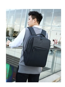 Outdoor shot of a sleek waterproof commute backpack showing dual zippers and side pockets