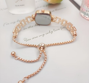 Detail of square rose gold watch with adjustable chain band and crystal accents