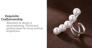 Detail view of five white pearls arranged on a polished silver-plated ear cuff