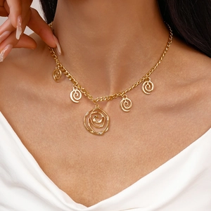 Detail of gold necklace featuring five spiral hollow flower pendants on thick chain