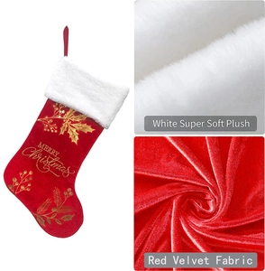 Detail of red velvet Christmas stocking with white plush cuff and gold festive lettering