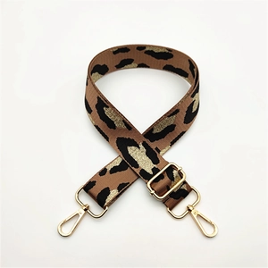 Close-up of leopard print shoulder strap with adjustable gold buckle and swivel snap hooks