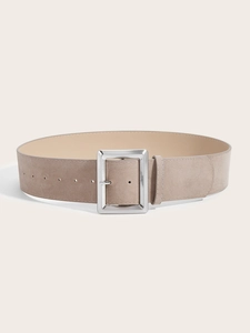 Détail d'une ceinture large en daim gris avec boucle carrée argentée sur fond minimaliste
