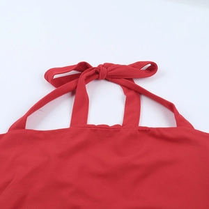 Detailed view of red halter neckline featuring an elegant bow tie on soft fabric