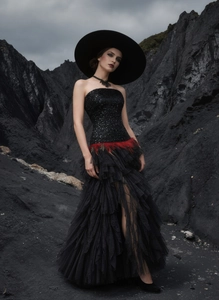 Detail of black sequined corset dress with red feathers and layered tulle skirt