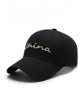 Close-up of gold 'china' cursive embroidery on a black twill cotton baseball cap