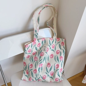 Gros plan du sac cabas en toile à fleurs avec tulipes roses et étiquette tissée