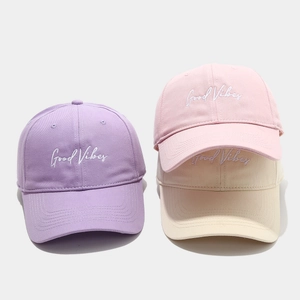 Detail of embroidered Good Vibes text on cotton baseball caps in pastel colors