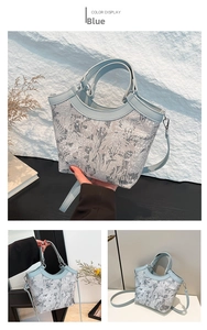 Macro detail of blue bucket bag with intricate floral embroidery and silk fabric texture