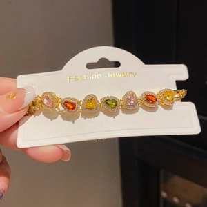 Detail of colorful teardrop gemstone bracelet with gold plating and sparkling zircon halos