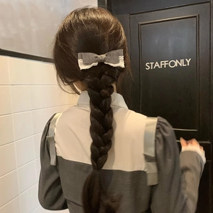 Elegant grey lace bow hair clip with flowing ribbons worn on a braided ponytail