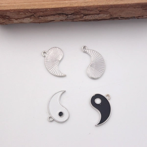 Detailed view of silver and black-white Yin Yang Tai Chi alloy pendants with oil dripping