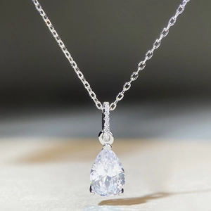 Macro shot of silver water drop necklace with teardrop zircon and pavé diamond detail