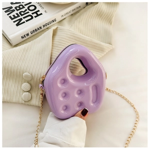 Detail of purple mini PVC jelly bag with asymmetric handle and golden chain strap