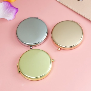 Detailed top view of round metal folding mirrors in silver, gold, and rose gold finishes