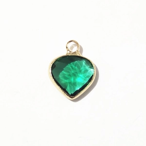 Macro detail of heart-shaped emerald green crystal pendant with gold alloy plating for DIY
