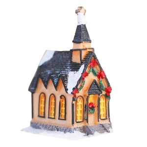 Illuminated Christmas snow church house with festive wreaths and glowing windows