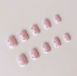 Detailed view of ballet French press-on nails with white tips and sparkling rhinestones