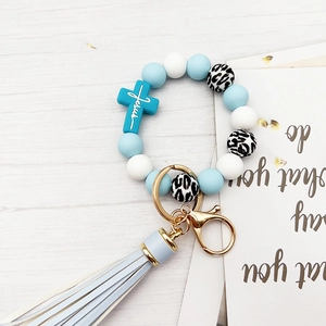 Detailed macro shot of blue silicone beads with gold ring and light blue leather tassel