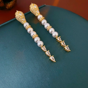 Detailed view of long gold tassel earrings with pearls and pear-shaped zircons