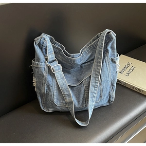 Détails du sac à bandoulière en denim bleu avec bords effilochés et boucles métalliques