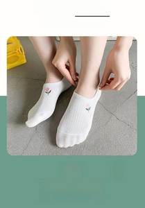 Detail of white cotton low cut socks with delicate tulip embroidery and elastic cuff