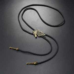 Detailed close-up of bronze wolf head pendant on black braided leather bolo tie necklace