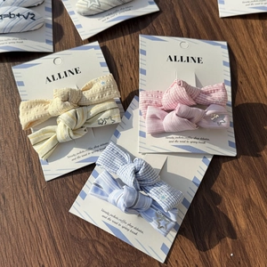 Set of two preppy style striped and plaid bow hair clips on a rustic wooden background