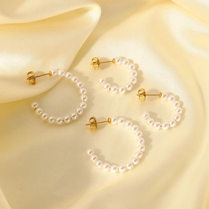 Elegant C-shaped pearl earrings in 18K gold plated stainless steel on silk background