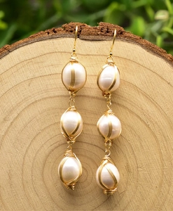 Detail of three freshwater pearl drop earrings with handmade gold wire wrapping