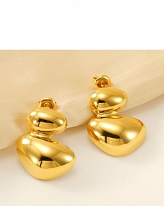 Detail of 18K gold plated irregular oval earrings on soft beige silk background