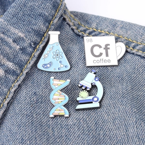 Science themed enamel pins set with beaker and DNA on blue denim jacket pocket