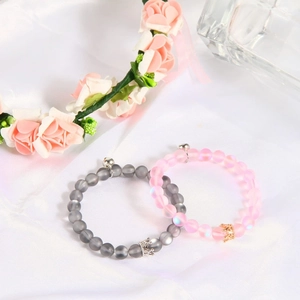 Detailed view of matte agate beaded crown bracelets for couples on elegant silk background