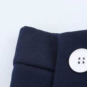Detail shot of navy blue A-line skirt fabric with premium white button and stitching