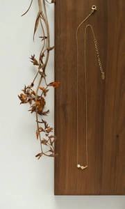 Détail du fermoir mousqueton et gravure S.Steel sur collier de perles minimaliste doré