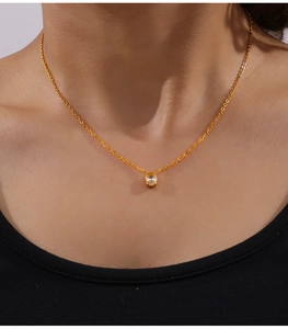 Close-up of minimalist gold plated necklace with oval cubic zirconia on model neck