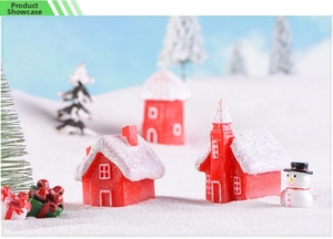 Close-up of resin Christmas house figurines with snowmen and glitter details in snow