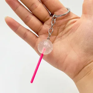Detailed macro of a realistic transparent lollipop keychain with pink plastic stick and ring