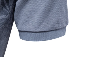 Macro detail of the ribbed cuff and breathable piqué knit fabric on blue polo shirt