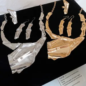 Irregular geometric pleated jewelry set with gold and silver lava texture on black velvet